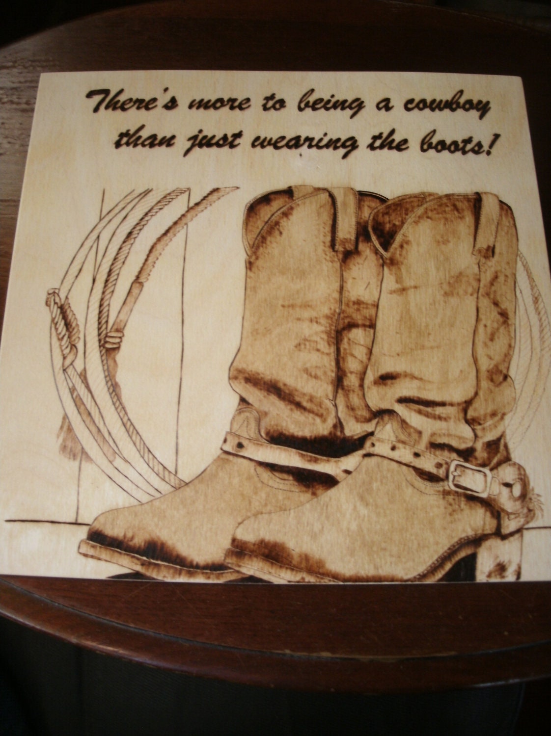 Woodburn art piece "There's more to being a Cowboy than just wearing the boots"