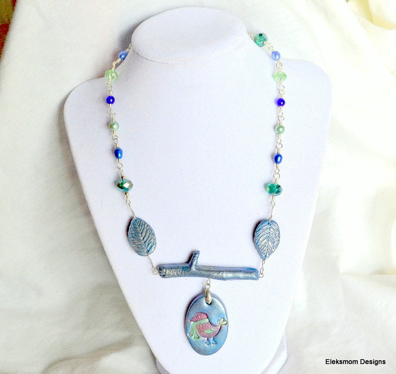 A little winter bird in polymer clay and hand wrapped freshwater pearls, crystals, and beads.