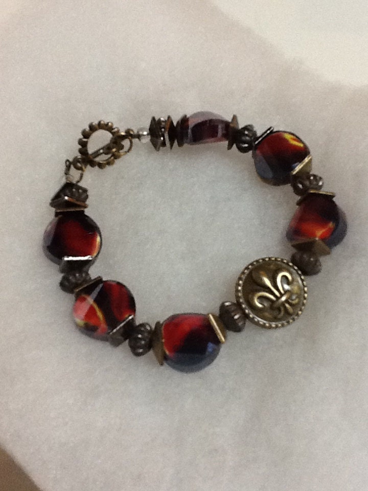 Fleur de Lis faceted glass bead bracelet, brass toggle multi colored