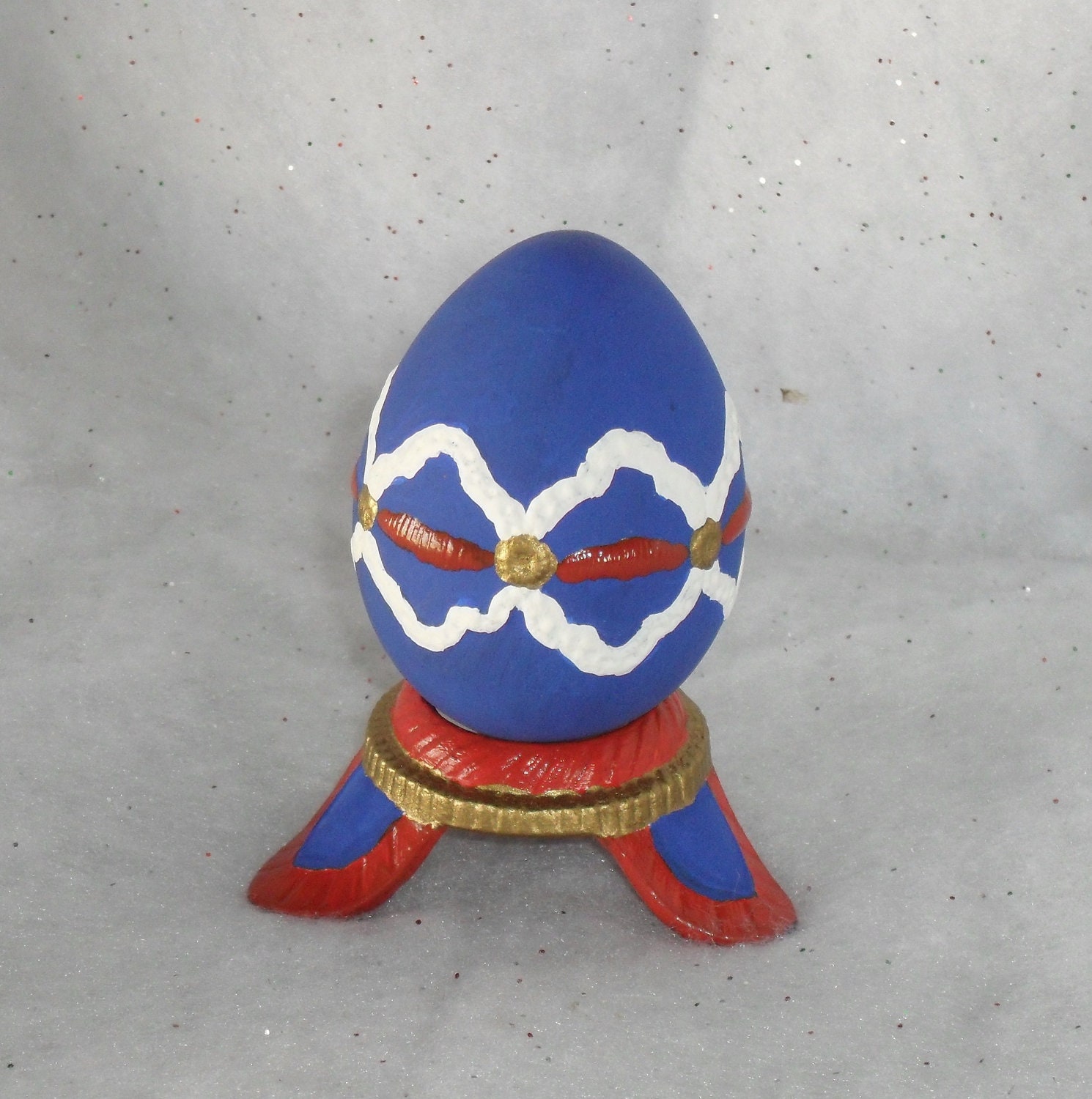 Elegant Easter Decoration. Blue Ceramic Decorative Easter Egg on Ornate Ceramic Stand.