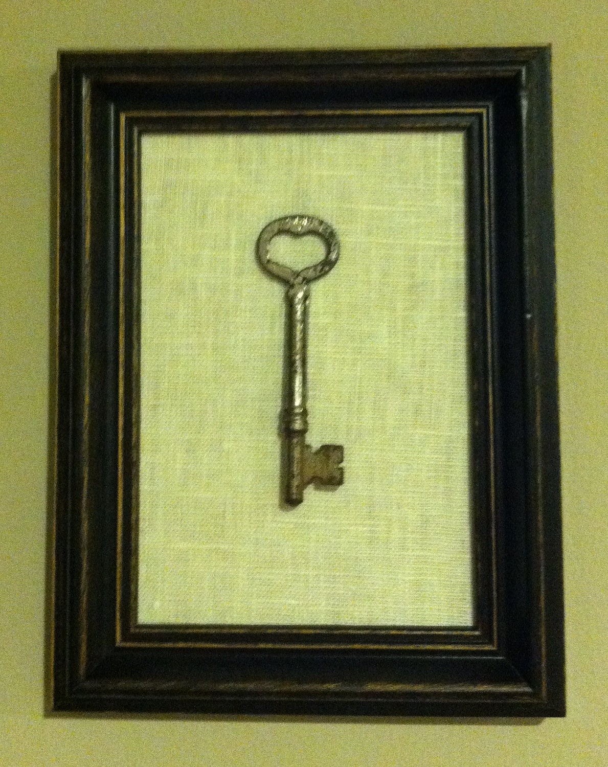antique skeleton key in distressed wooden frame