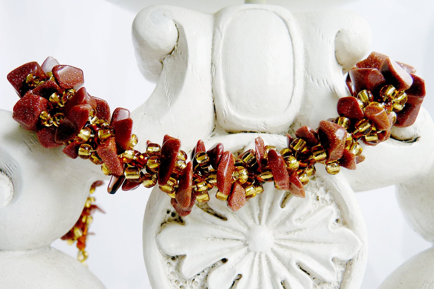 Woven spiral rope bracelet featuring goldstone chips and a magnetic clasp