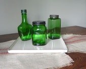 Vintage green bottles on white enamel metal tray medical
