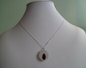 A stunning very rare ruby red Victorian English seaglass pendant, sitting on a ice white frosted base. ASG73