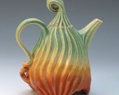 Porcelain teapot with carved grooves in green, tan and orange glazes