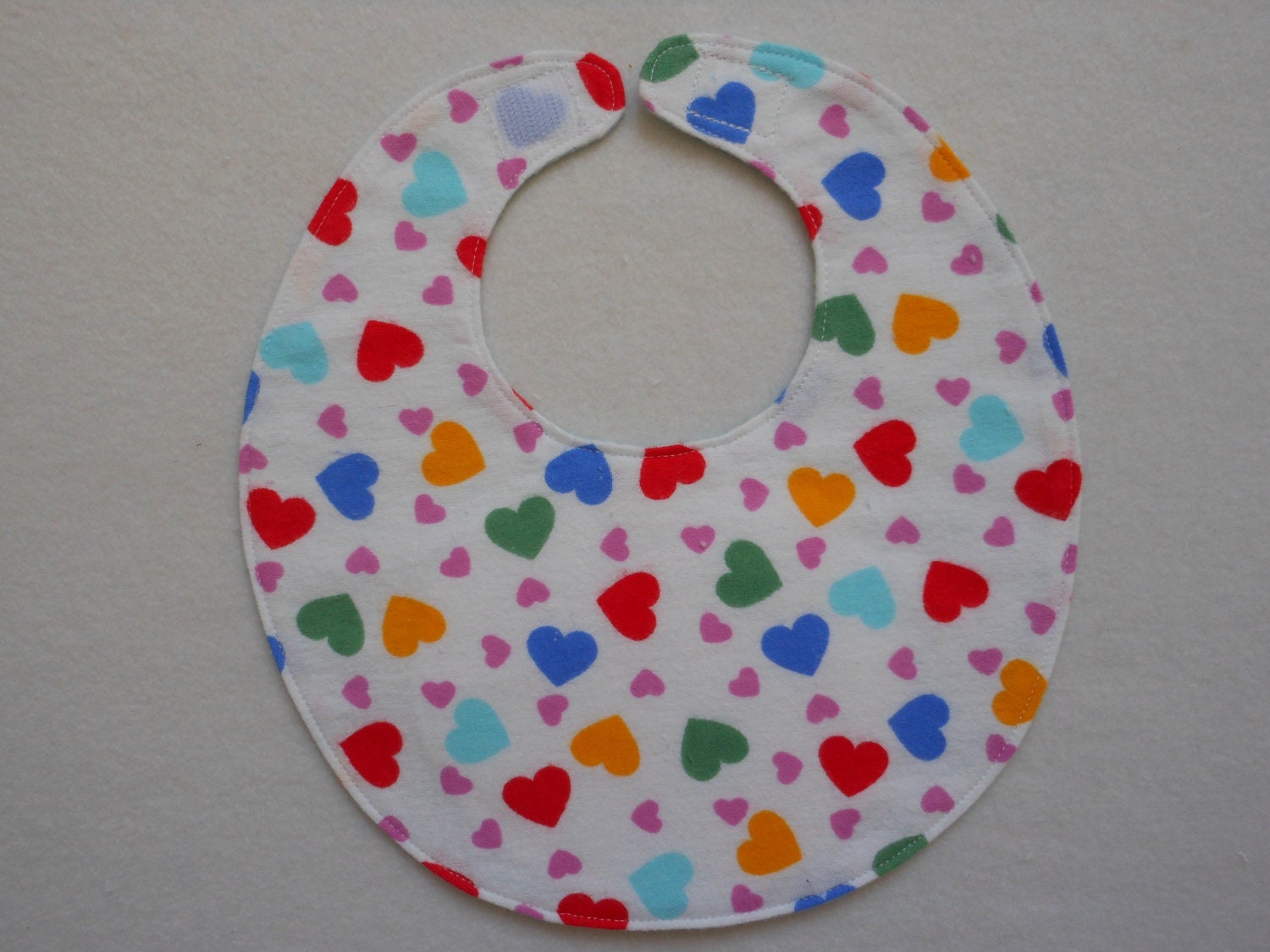 Baby bib, four soft layers, reversible, white bright red, blue, and yellow hearts
