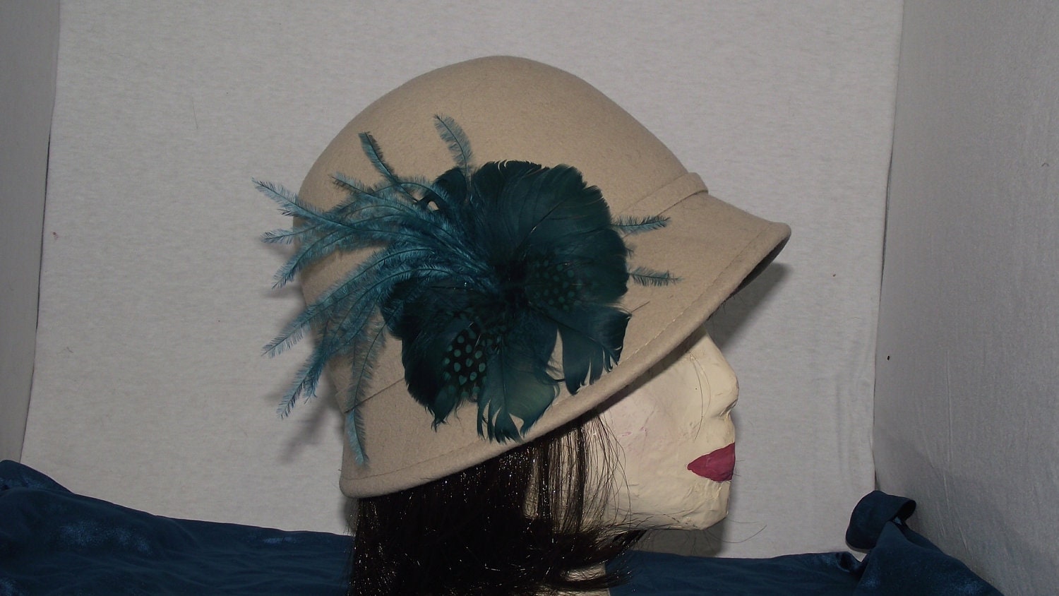 Light tan ladies cloche hat teal feather embellishment
