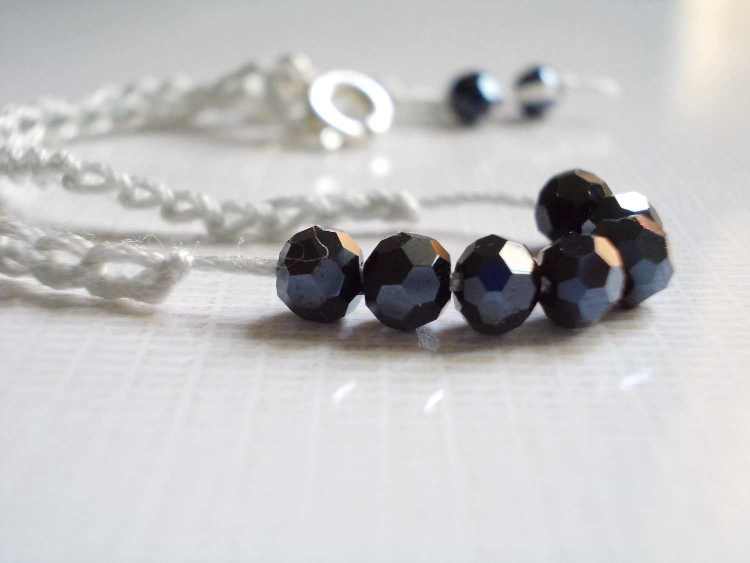Black and gray. Bracelet. Crochet. Sparkling black glass faceted beads and gray cotton.