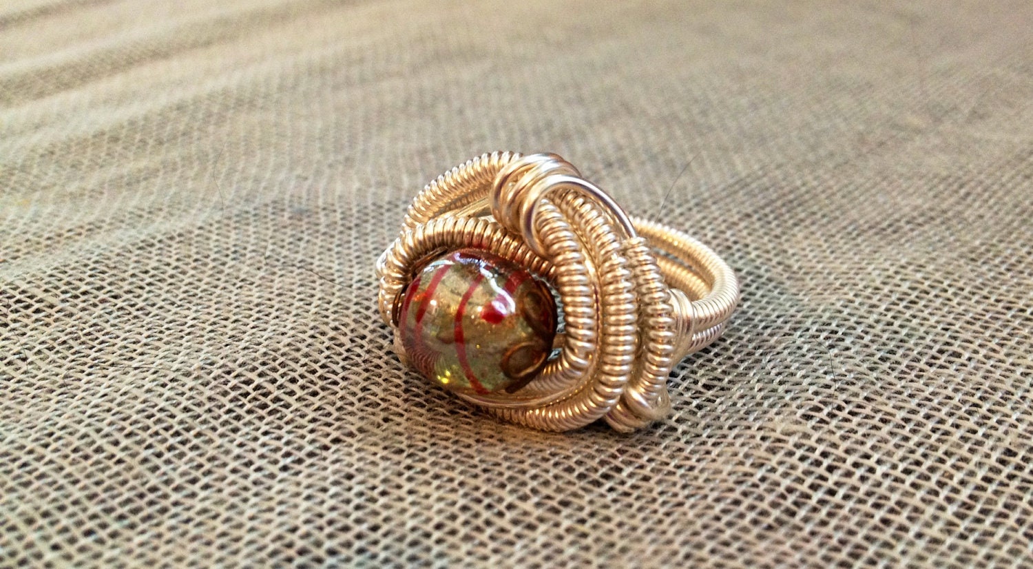 Lampwork Glass Wrap Ring...PJIve wire wrapped ring size 9 in silver wire around a beautiful siler and red stripped lampwork bead.