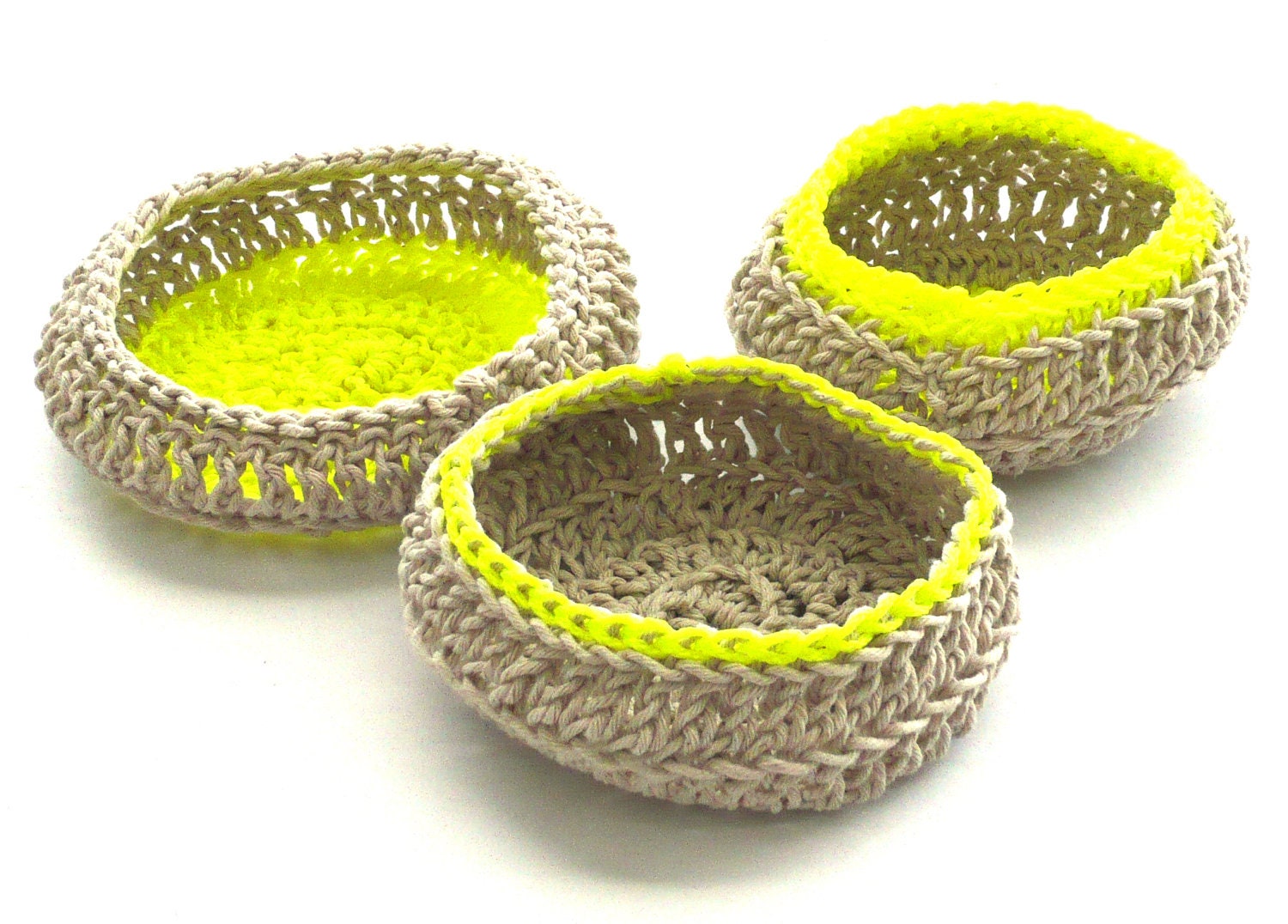 A set of three natural cotton crocheted jewellery baskets, with contrasting bright neon thread