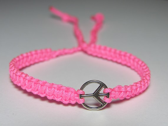 Bracelet with tiny peace sign and bright pink nylon thread