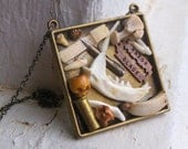 Cabinet of Curiosities. Skull, Bone, Razor blade, teeth, jaw, bullet shell, pen nib, bullet shell .Framed wearable 3D art necklace