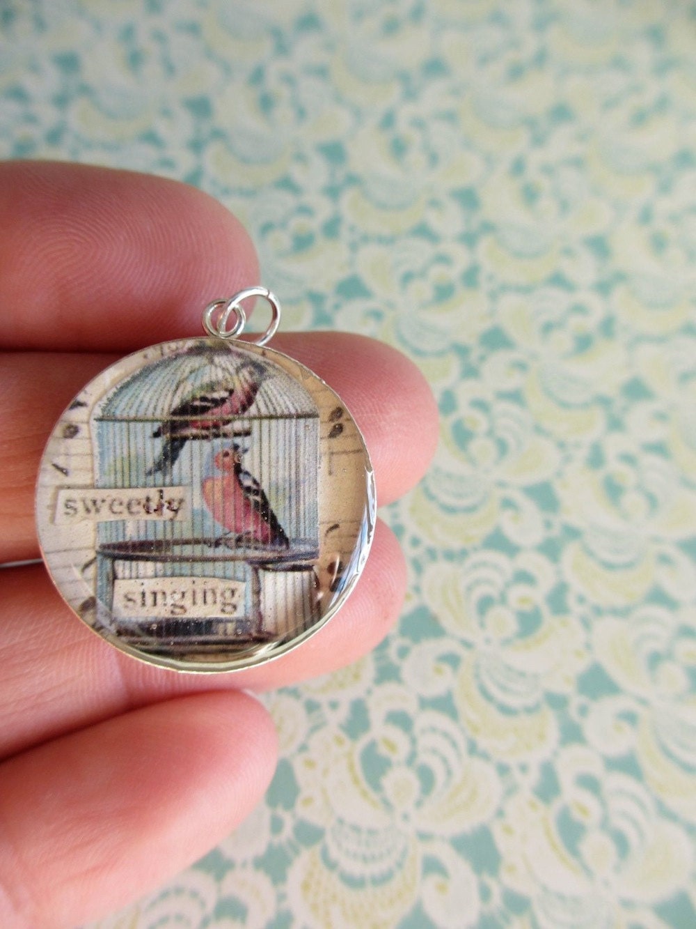 Vintage birds in birdcage set under resin in a sterling silver pendant