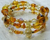 Recycled glass lampwork beads and amber bracelet on three coils of memory wire - upcycled gold and amber bracelet