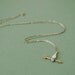 Hand with golden arrow necklace