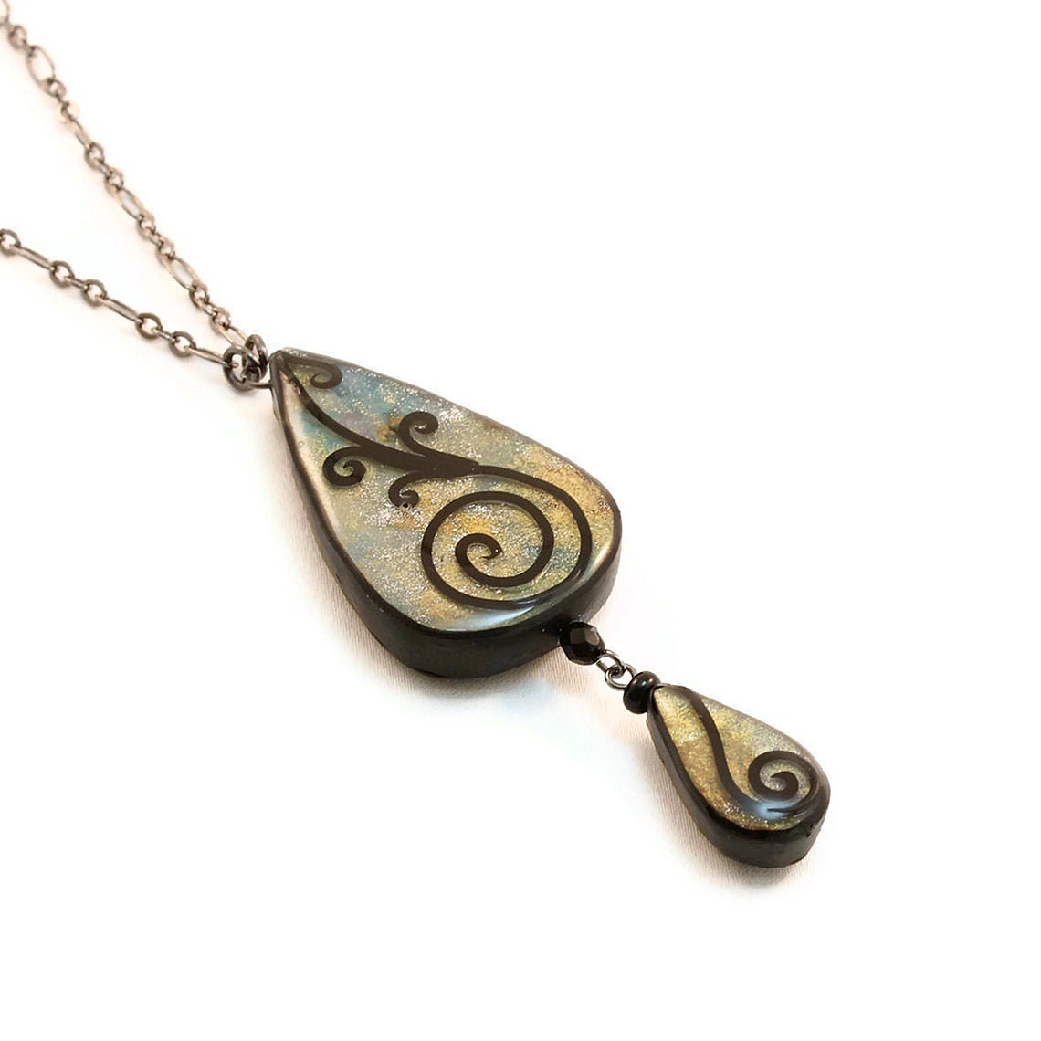 Teardrop necklace in shades of blue and gold with spiral design