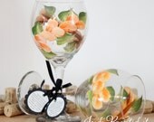 Hand painted wine glass in a vivid orange around floral design. Dishwasher safe