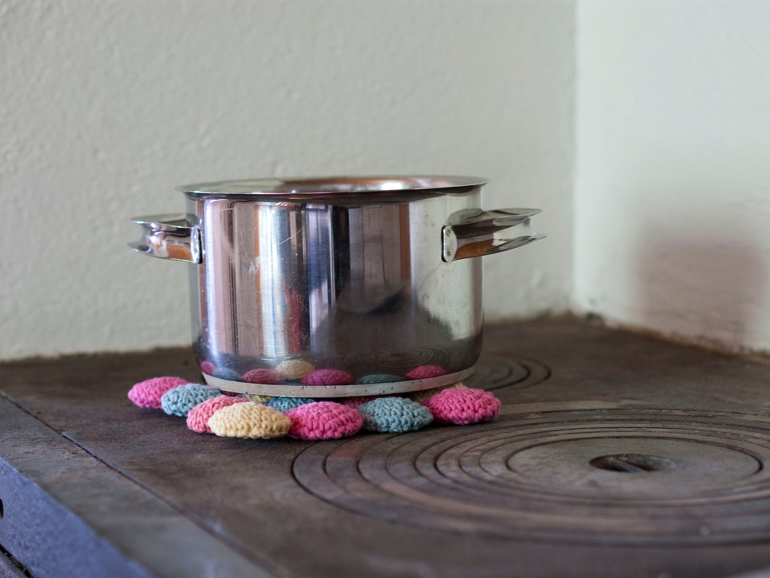 Eco cotton and wood trivet in pastels. Crocheted circles in pink, peach, yellow and blue. Eco friendly.