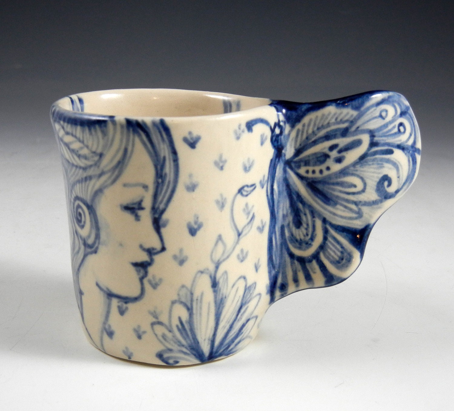 Blue and white porcelain cup with butterfly wing and three faces