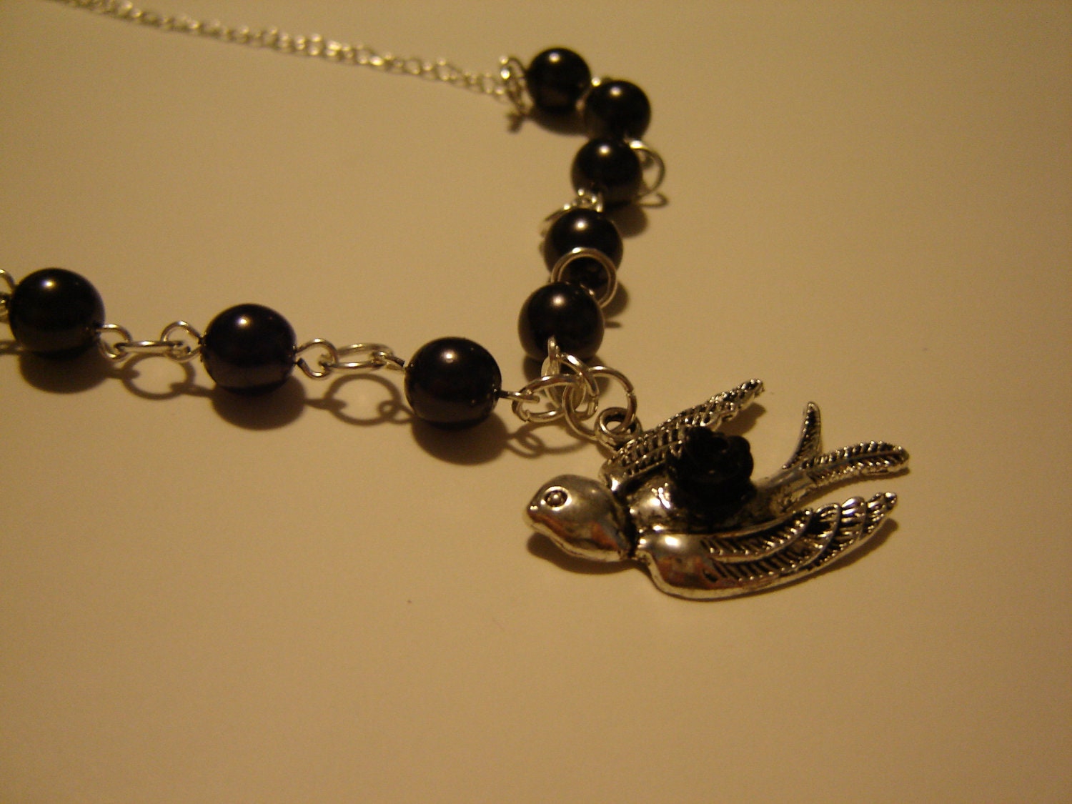 Silver tone necklace with black Czech glass pearls and bird charm with flower