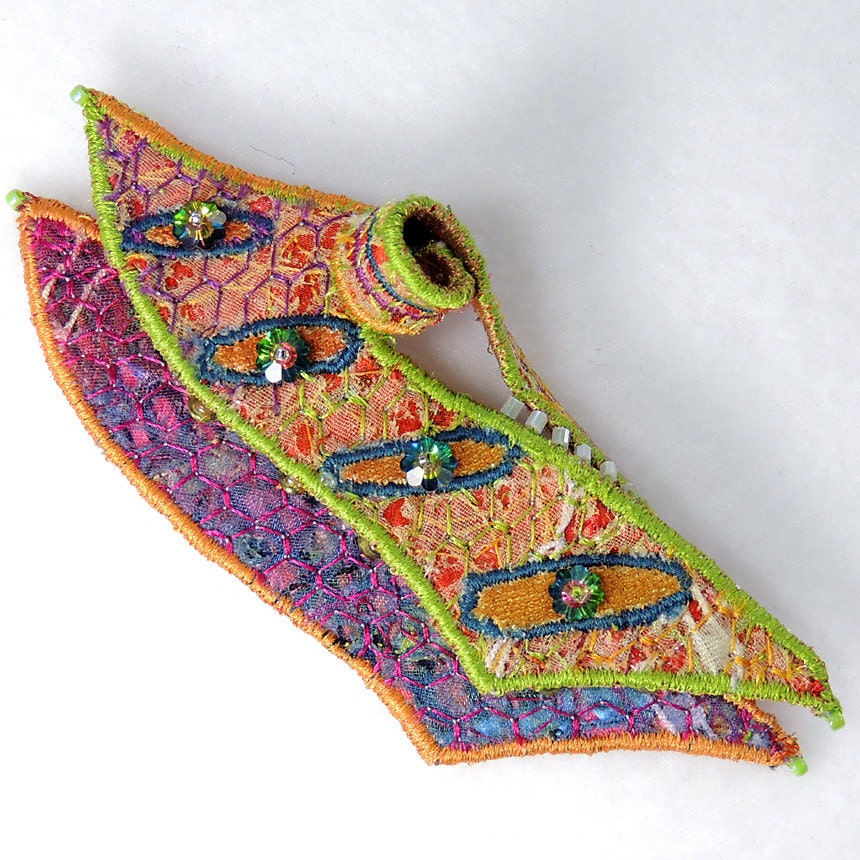 Textile brooch in orange, purple and lime