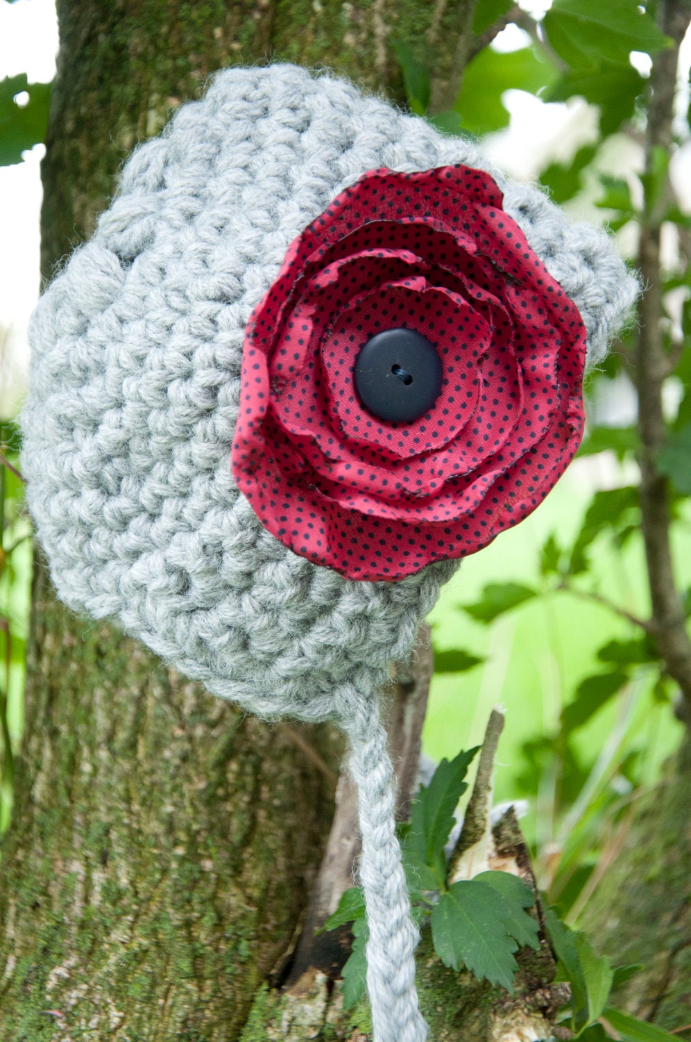 Crocheted newborn bonnet with flower accent
