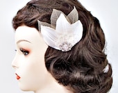 Bridal vintage looking hair clip of ivory satin and skelton petals with a crystal rhinestone focal point.