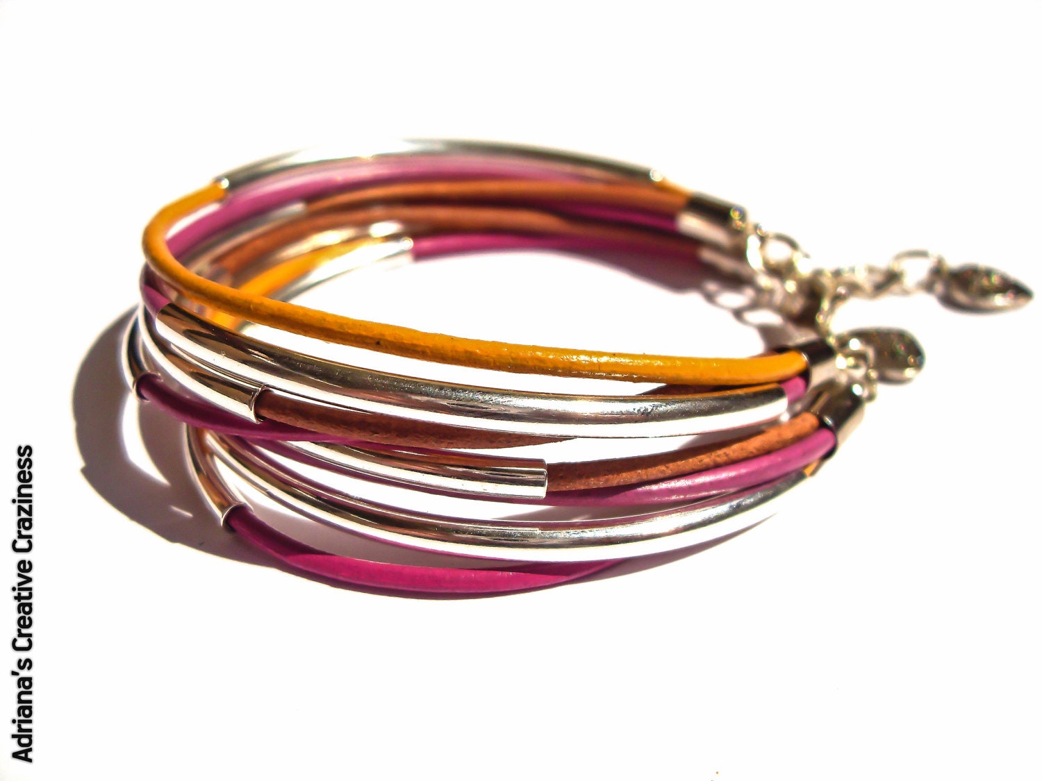 Yellow, fucsia, natural bracelet with leather ropes and silver tubes.