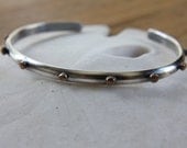 Single thin sterling cuff bracelet with hammered bronze studs