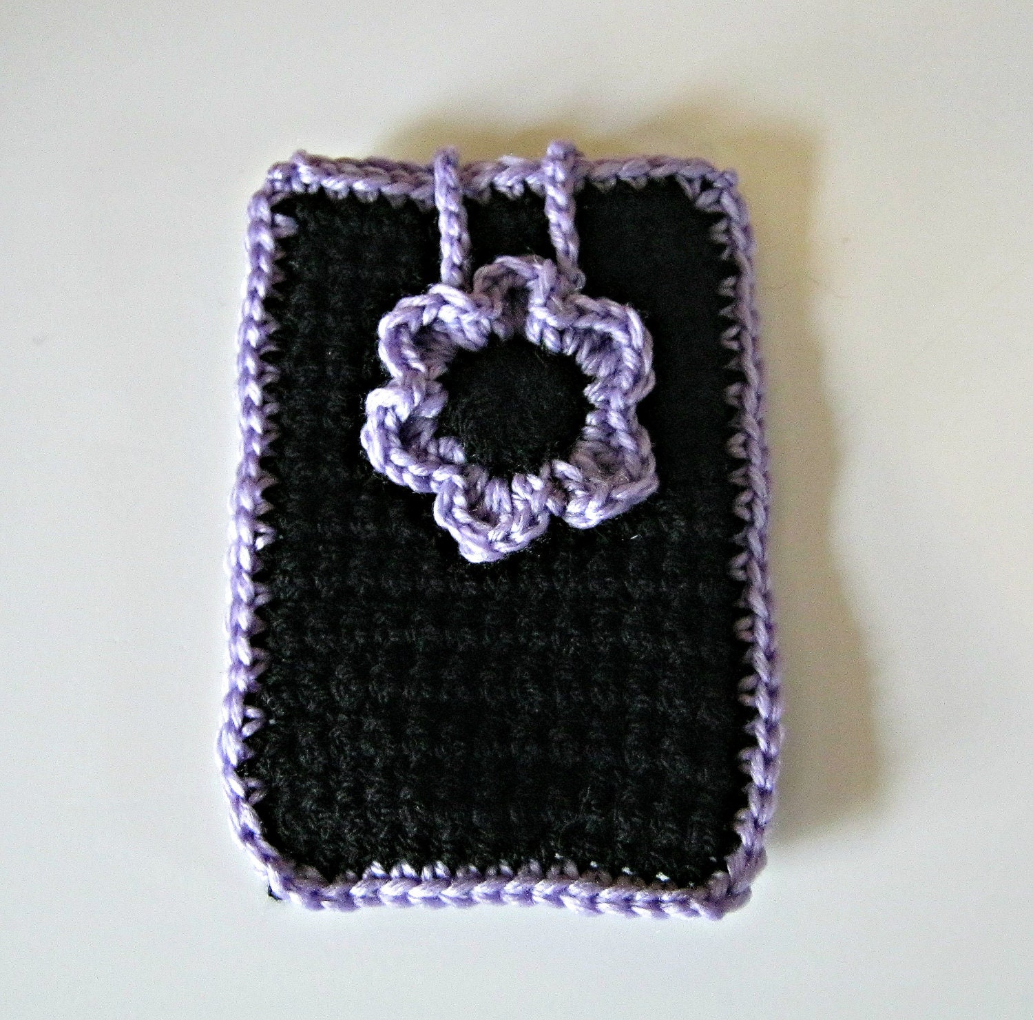 Crocheted phone cover in black with a lavender flower and trim