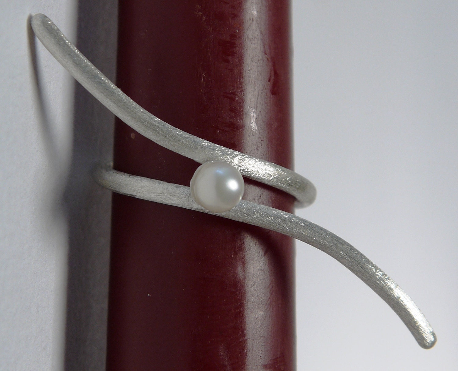 Handmade silver ring with a freshwater pearl in the center. Made of sterling silver wire with a simple and elegant design.