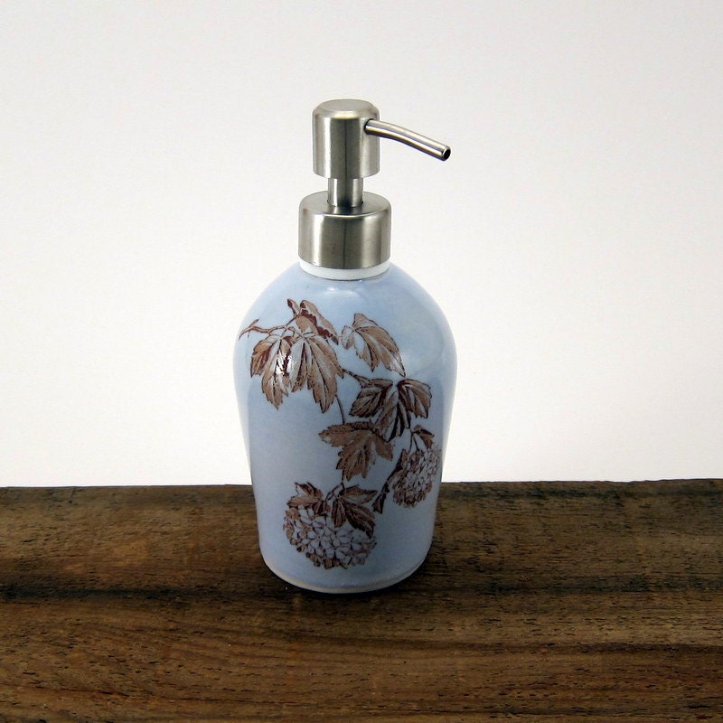 Blue glazed soap dispenser with floral image and brushed nickel pump