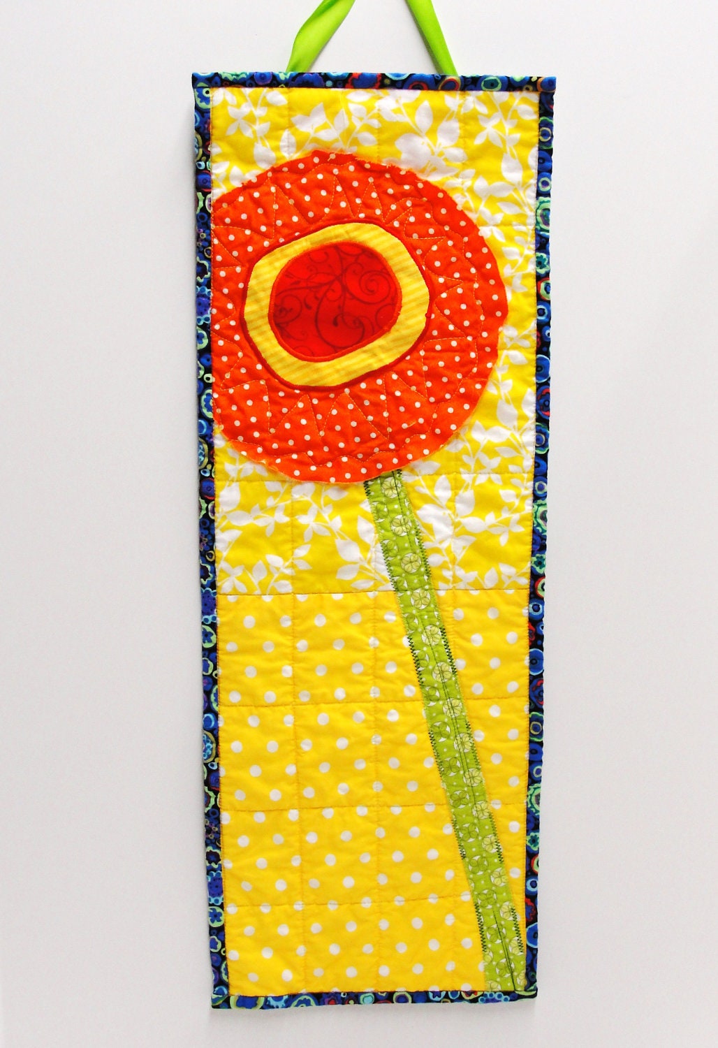 poppy wall quilt- single stem bright orange, yellow and red on yellow and white background