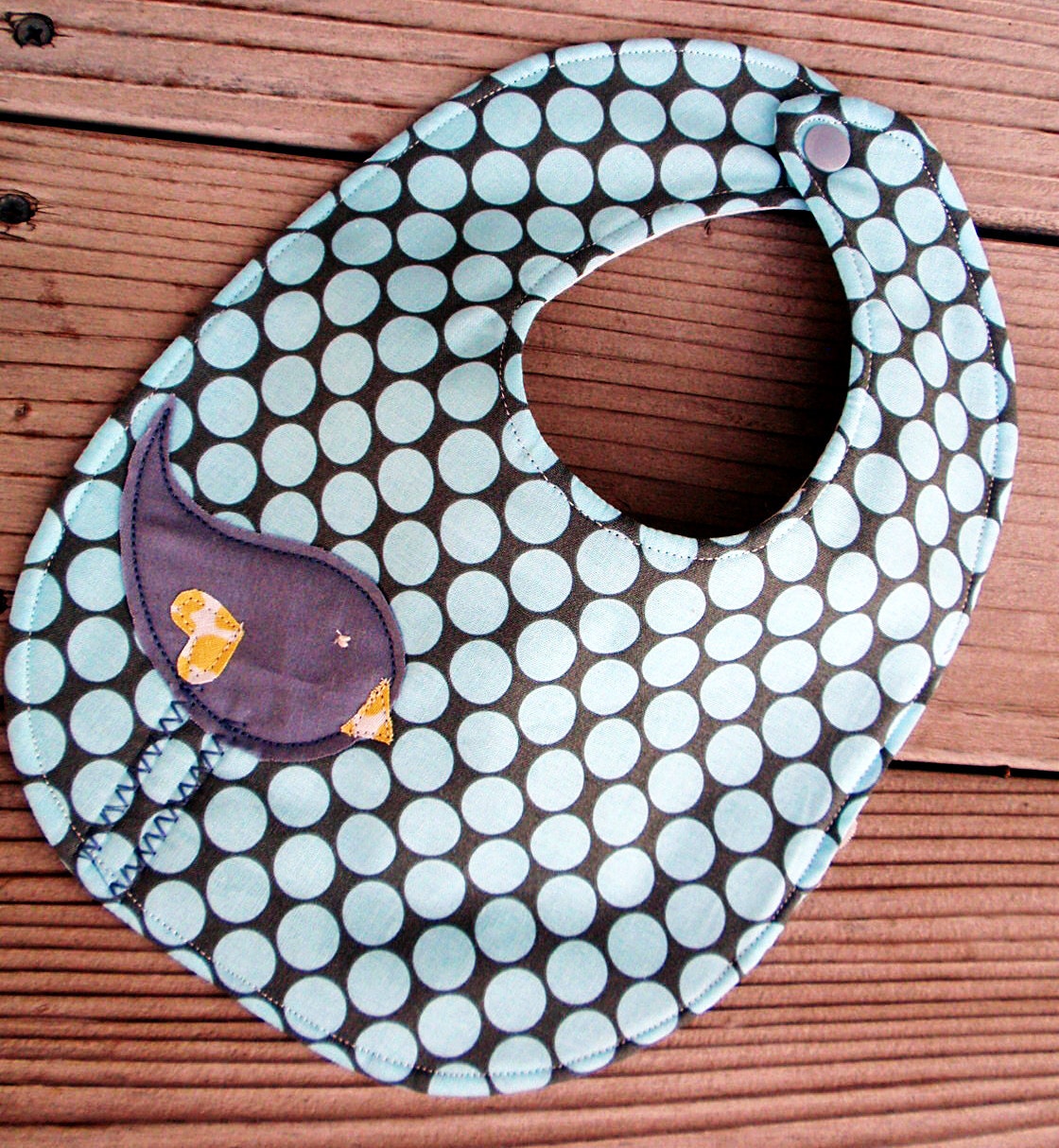 Blue polka dot baby bib with grey bird
