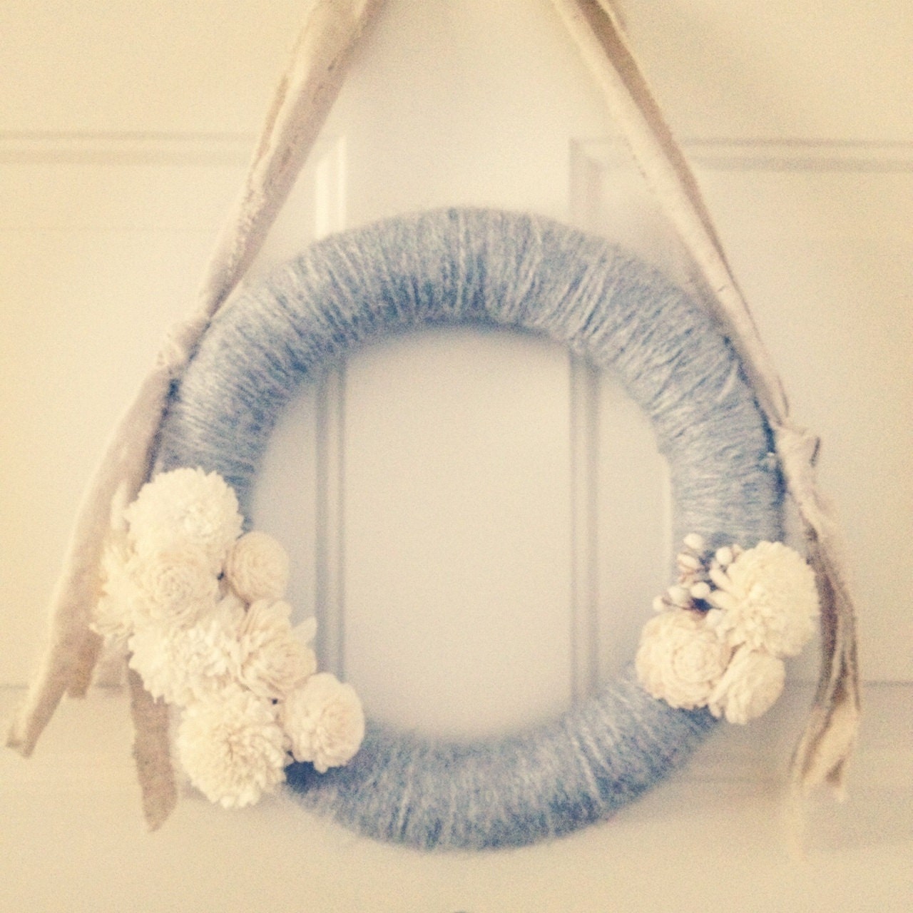 Grey yarn wrapped wreath with balsa wood flowers and tallow berries
