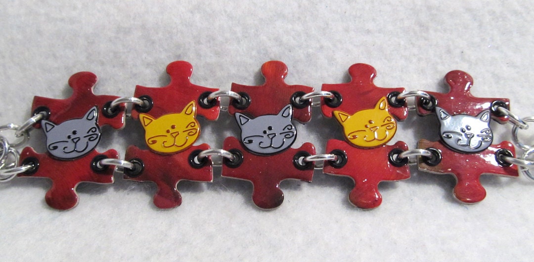 Reversible Puzzle Bracelet with big red puzzle pieces and cat charms