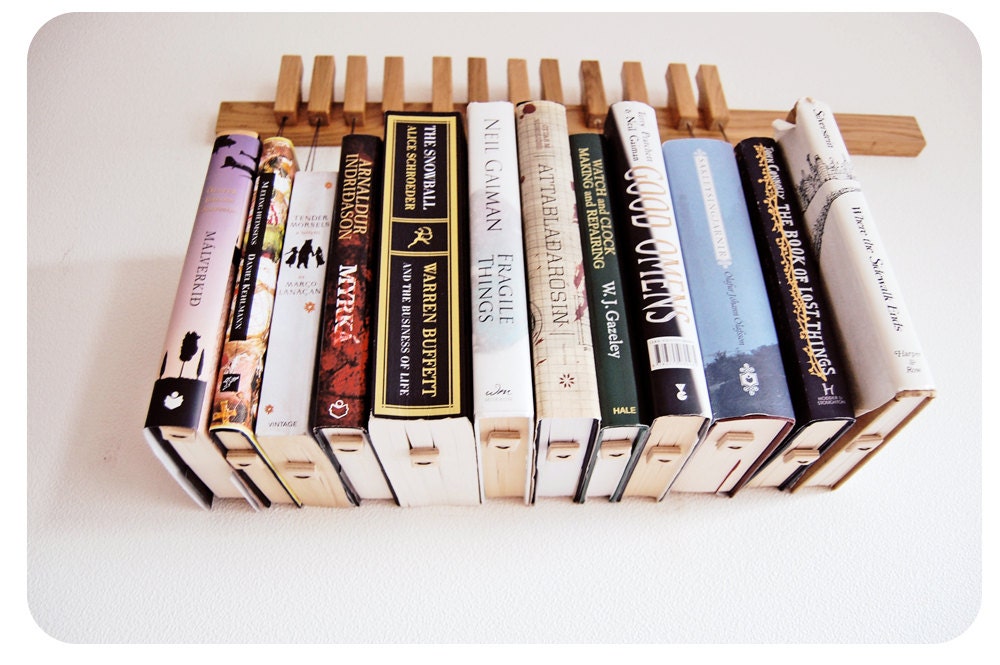 Custom made wooden book rack / bookshelf in Oak. The pins are also bookmarks.