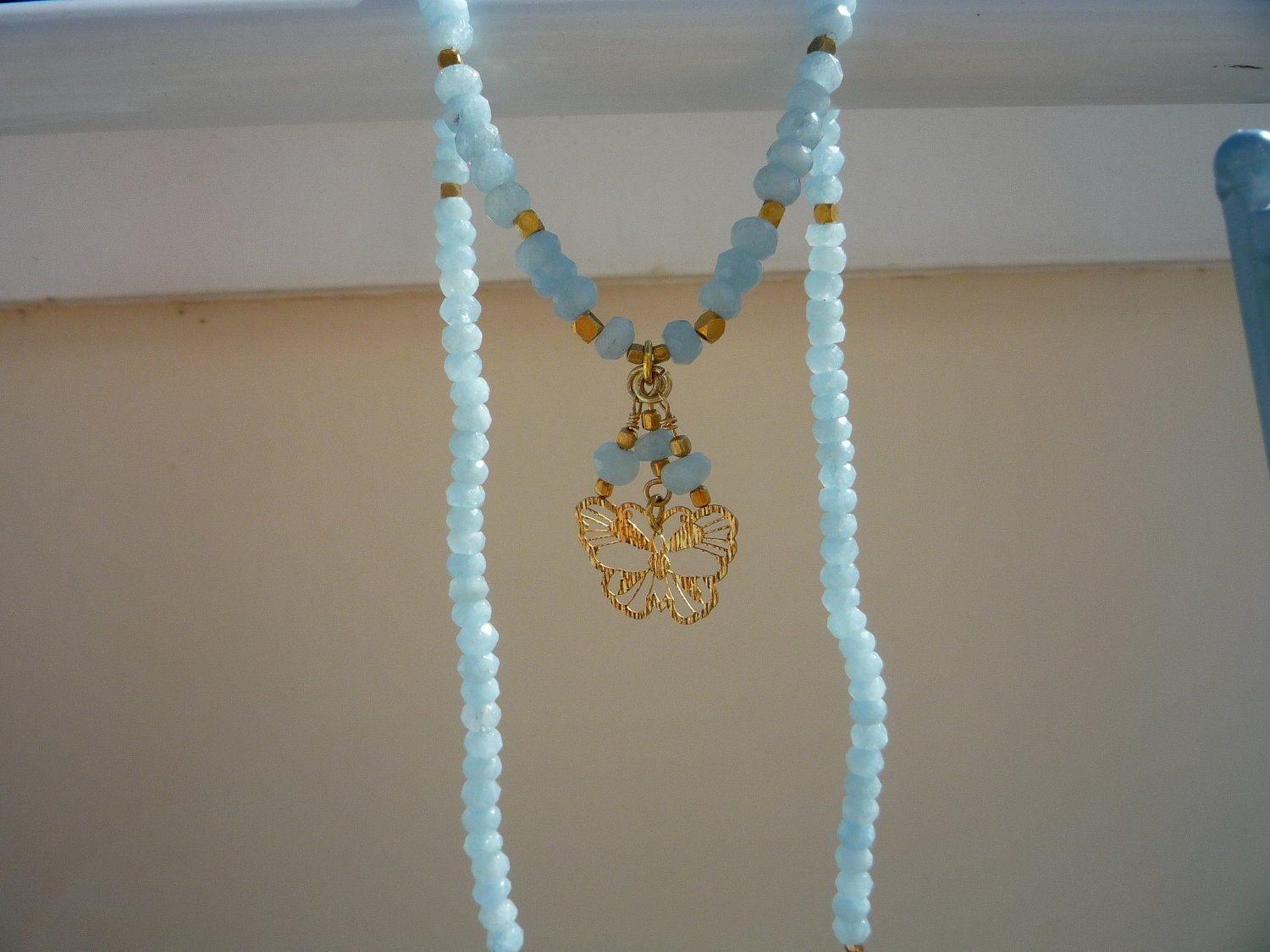 Natural Faceted Aquamarine rondelles  necklace with gold butterfly pendant.