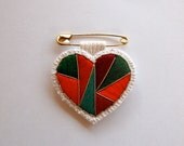 Christmas heart pin embroidered geometric design in reds greens and gold on gold safety pin
