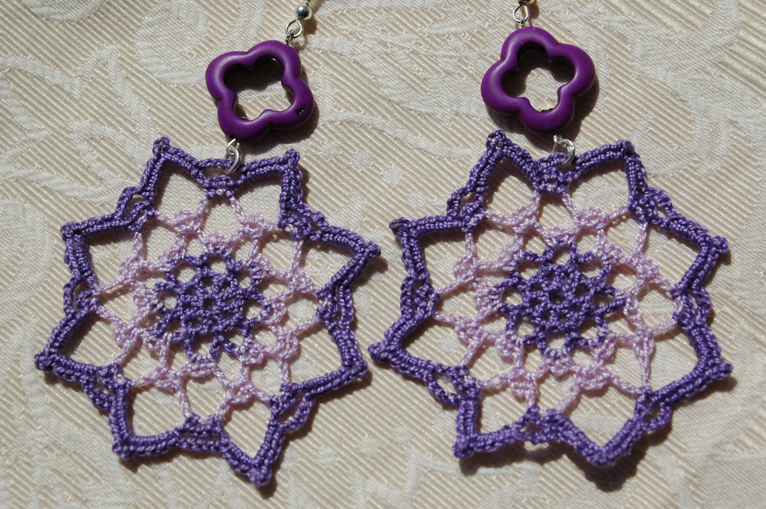 Eight pointed star crochet earrings. In violet color.