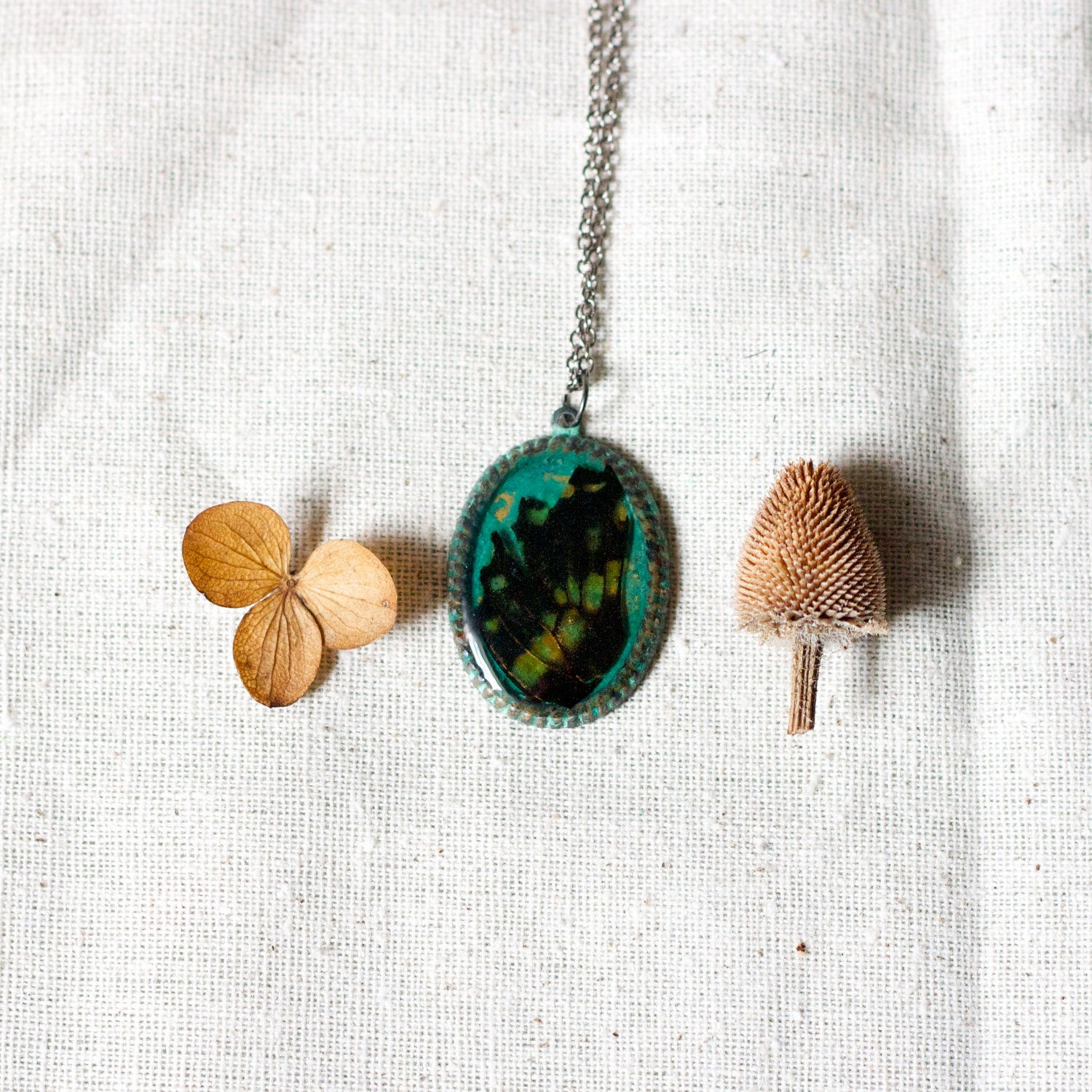 real butterfly wing necklace on green verdigris patina filigree bezel. black gold green. studiobotanica.