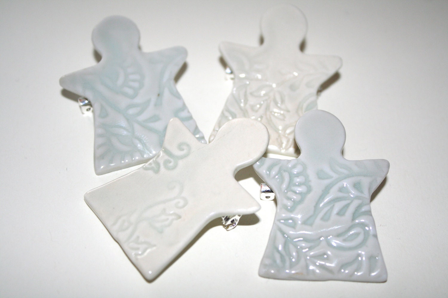 Porcelain ceramic angel brooch, in pale green glaze, impressed designs