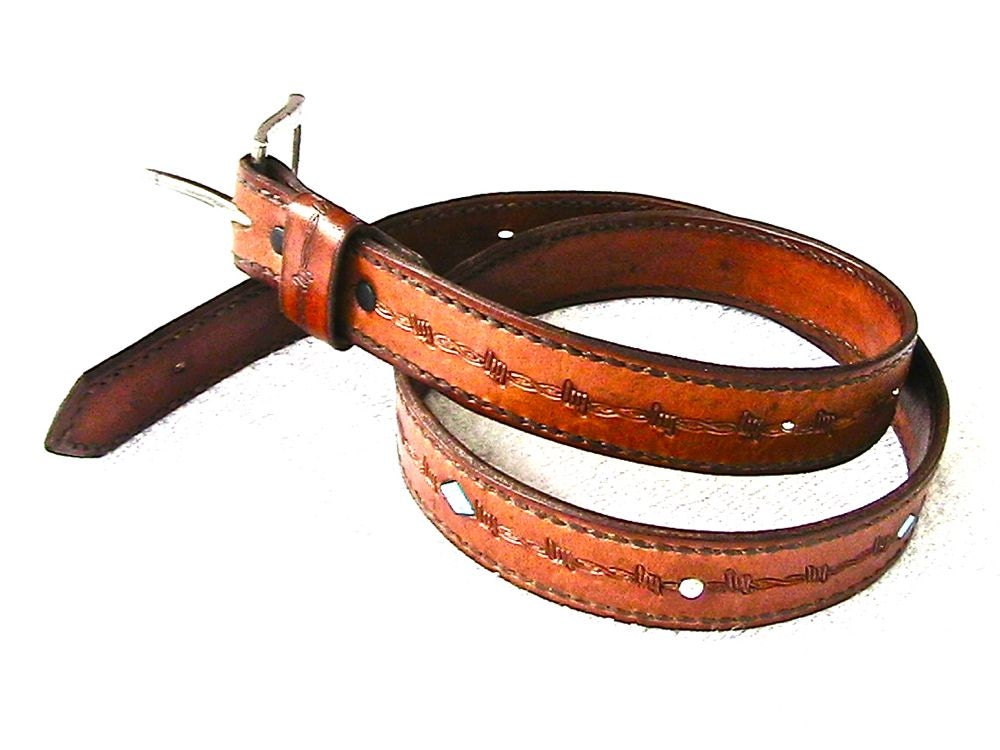Leather belt with turquoise and silver bead inlay and barbed wire motif.