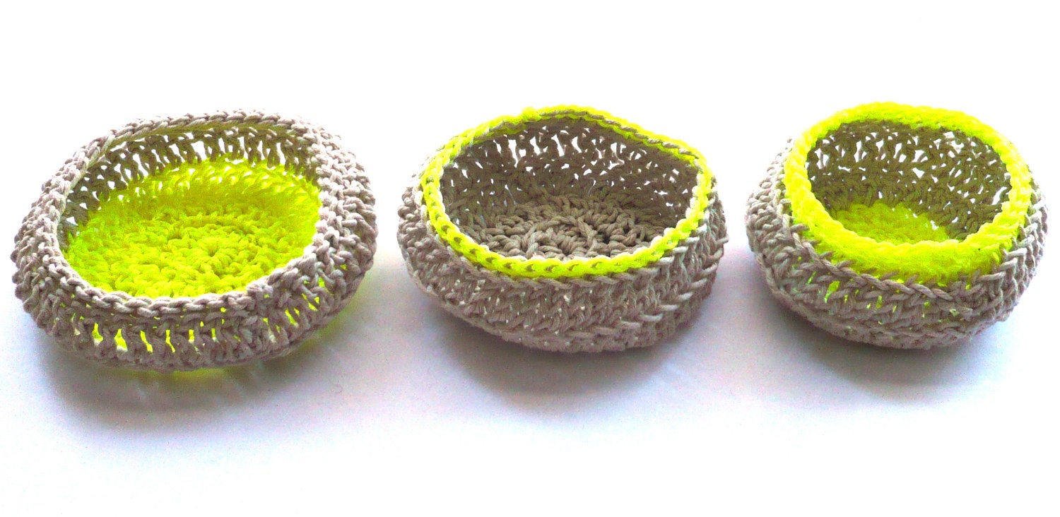 A set of three natural cotton crocheted jewellery baskets, with contrasting bright neon thread