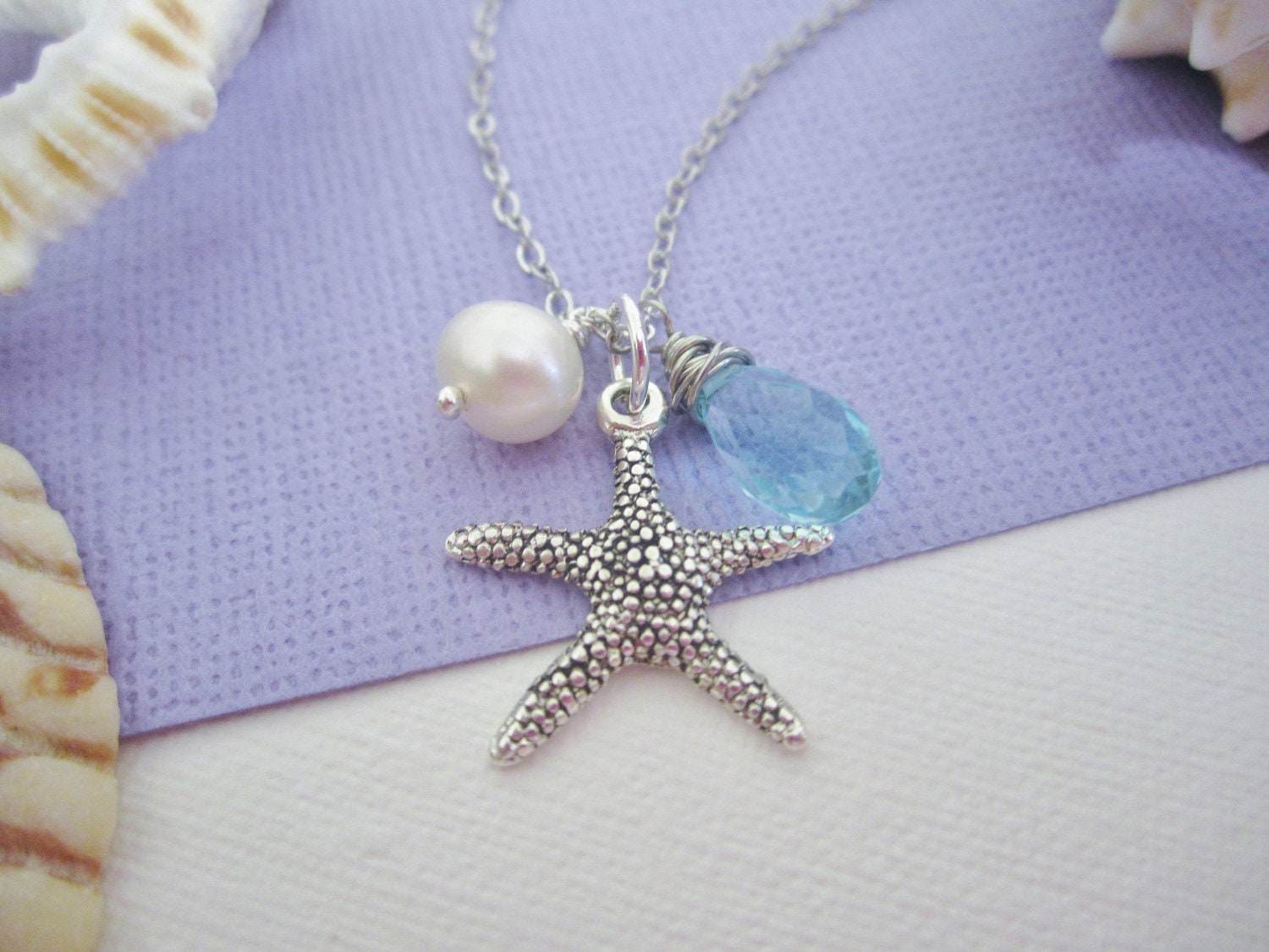 Silver starfish necklace with freshwater pearl and wire wrapped blue glass bead