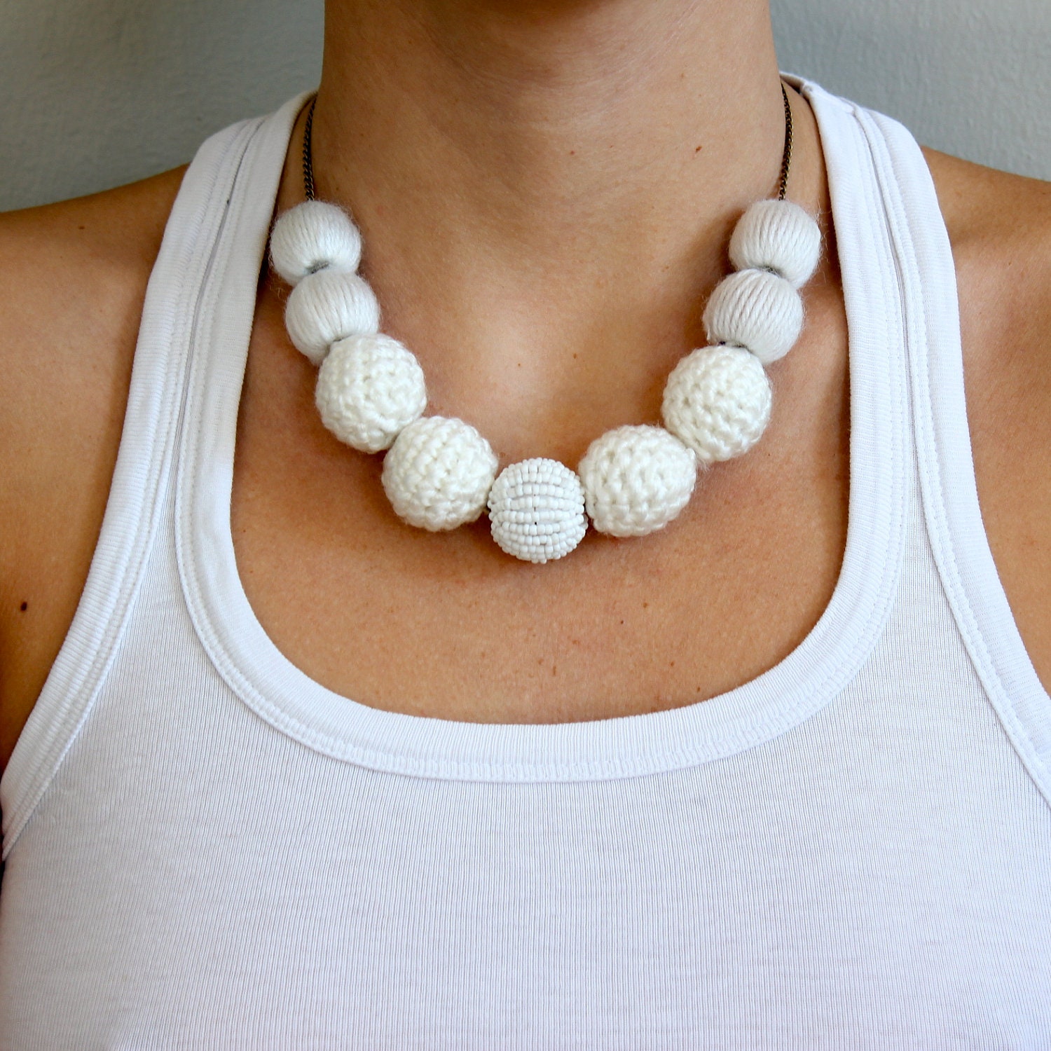 Handmade white wool and beads. Also comes with a handmade cotton bag for safekeeping. 