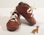 Baby shoes in toffee brown colour, 100% leather inside and outside. Beige or yellow cotton laces