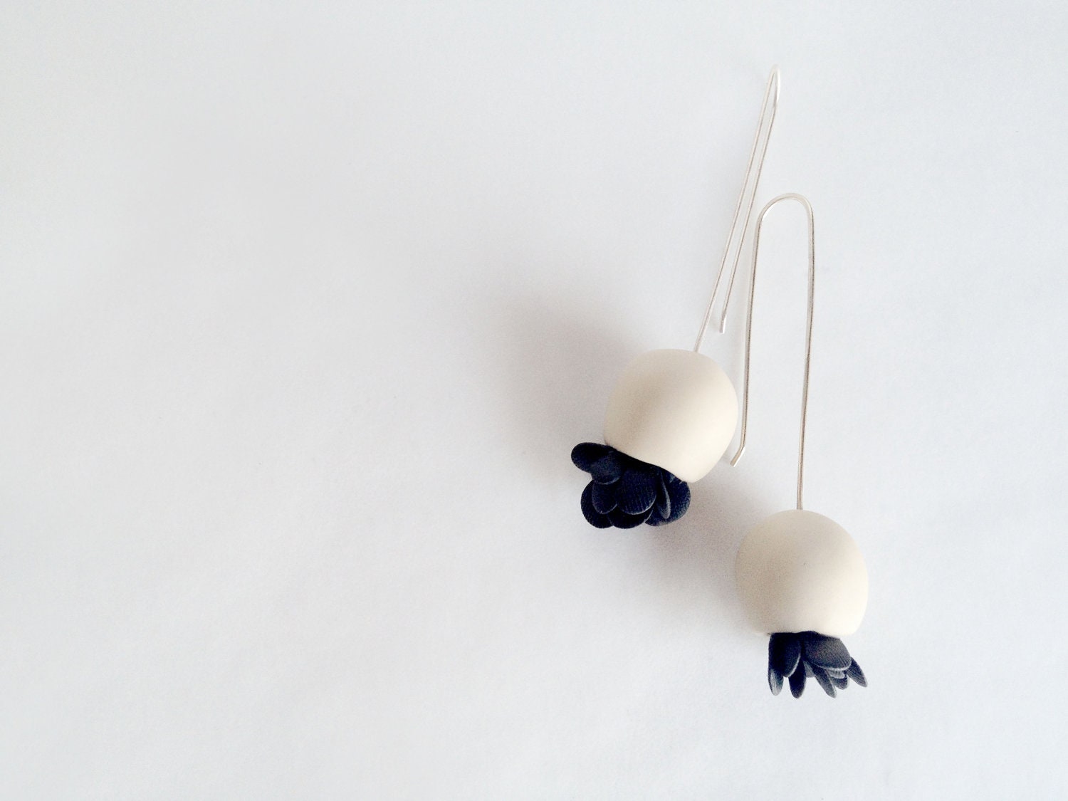 minimalistic hand sculped bell flower polymer clay earrings in off white colour with black elements , made to order