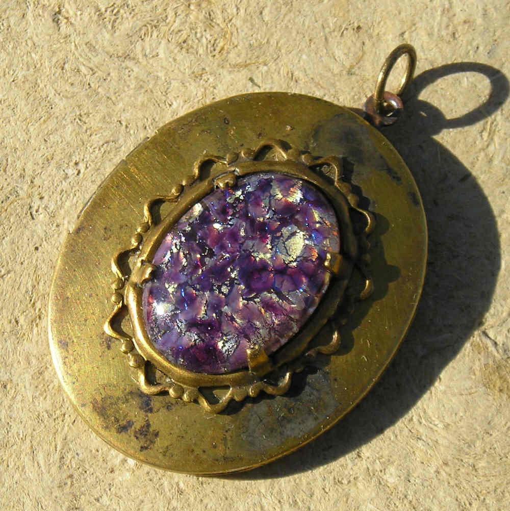 Beautiful vintage brass locket, large and lovely, set with old harlequin glass in amethyst.