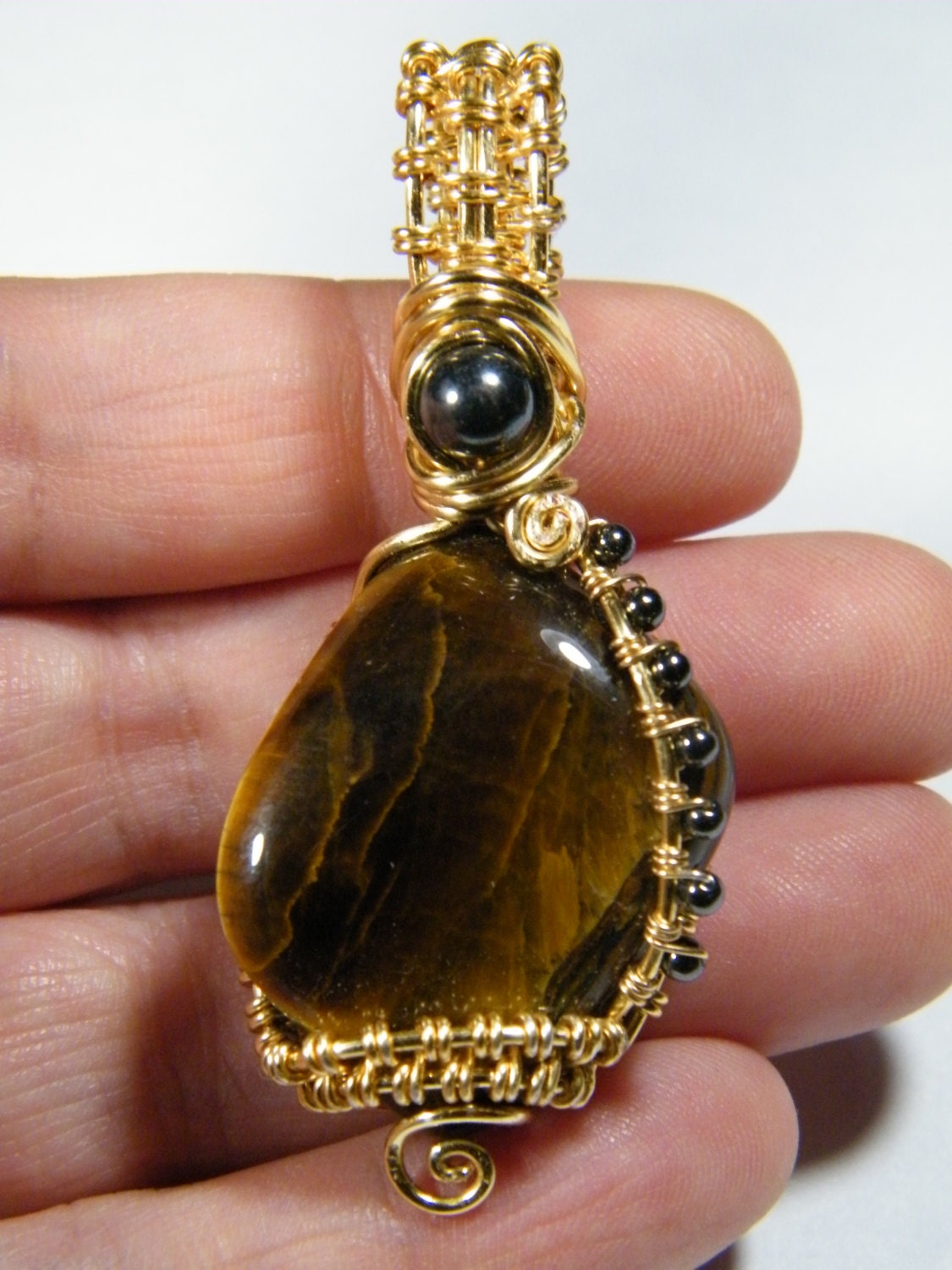 Woven wire wraped tumbled Tiger Eye with Hematite pendant
